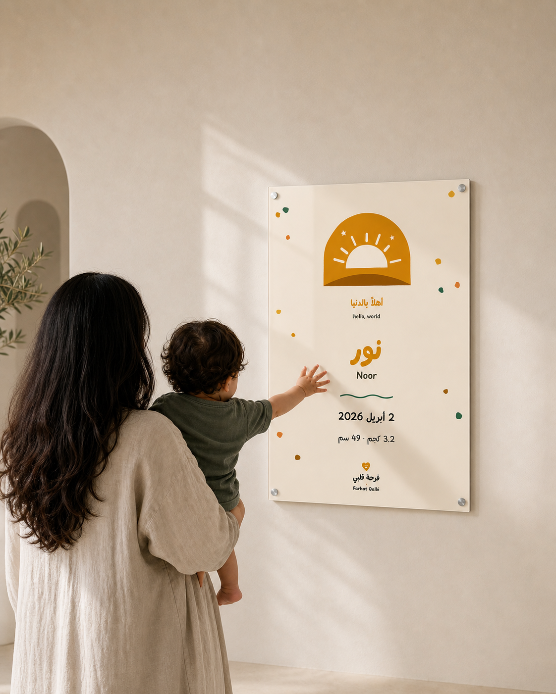Mother and baby looking at a personalised Noor acrylic birth print in a warm nursery